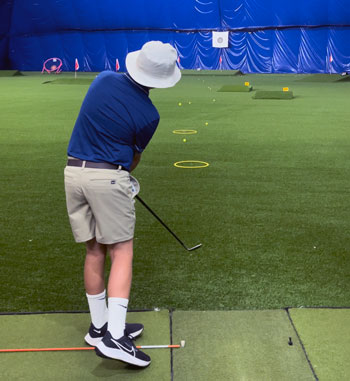 Junior chipping onto indoor range at The Golf Dome